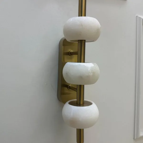 Unlit alabaster bead wall light showing white stone and brass-finish rod