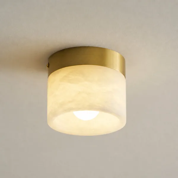 Small alabaster ceiling light glowing warm white on a ceiling