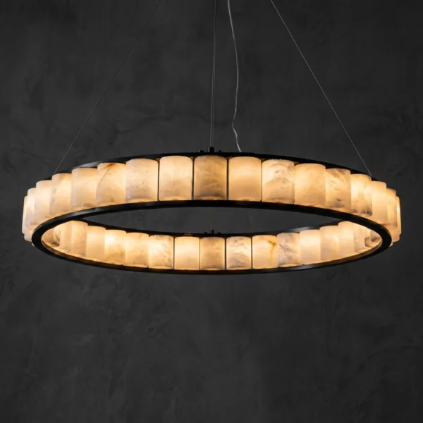 Alabaster cylinder ring chandelier lit, warm glow against a dark wall