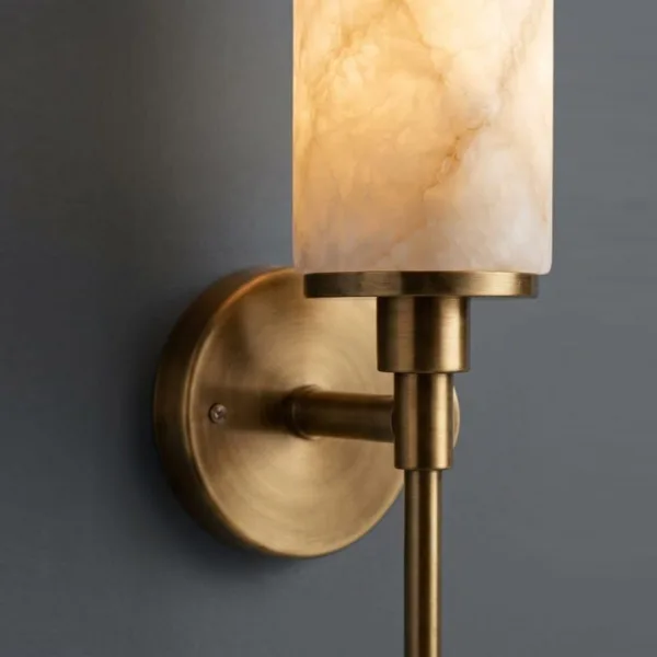 Close-up of the alabaster shade in its brushed brass-finish cup and round wall plate