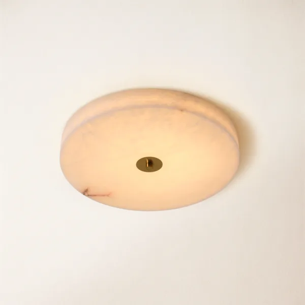 Round alabaster LED ceiling light glowing warm white with brass-finish centre cap