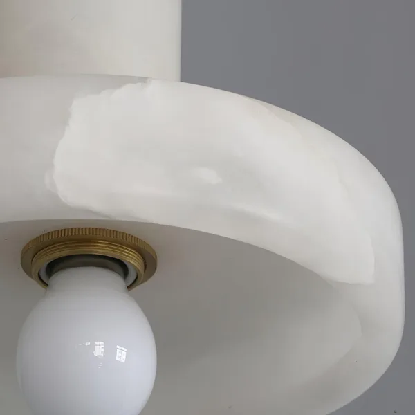 Close-up of the alabaster disc pendant light with its satin gold E27 socket ring and natural stone veins