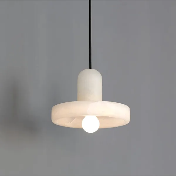 Alabaster disc pendant light glowing softly against a grey wall, light passing through the stone disc