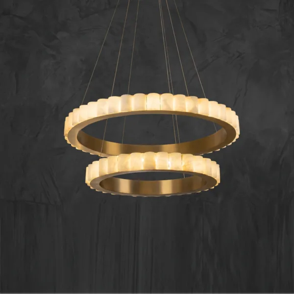 Alabaster double ring chandelier lit, warm glow against a dark wall