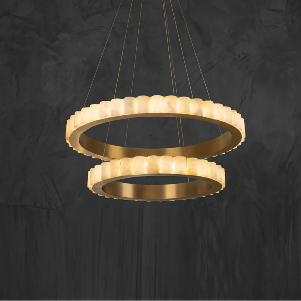 Alabaster double ring chandelier lit, warm glow against a dark wall