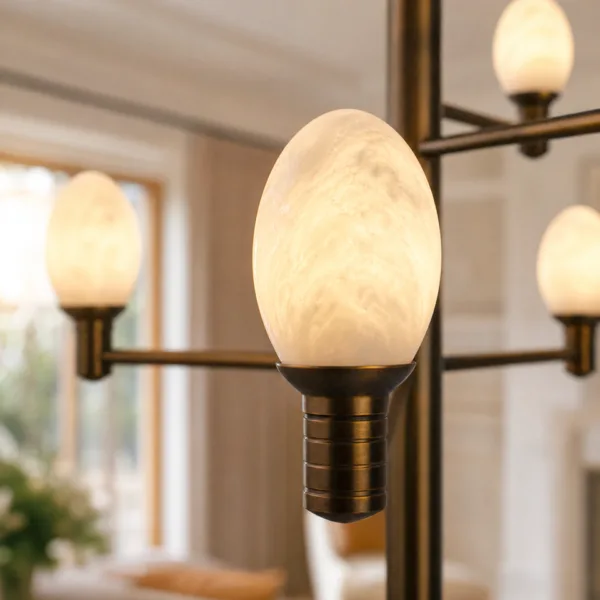 Close-up of one glowing alabaster egg shade and brass holder on the alabaster egg chandelier