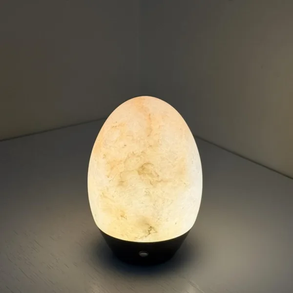 Alabaster egg night lamp glowing in the corner of a shelf