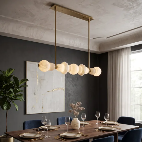 Alabaster orb linear chandelier hanging over a dining table in a dark dining room