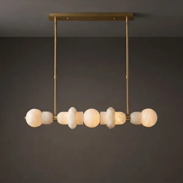 Lit alabaster orb linear chandelier with brass rods on a grey wall