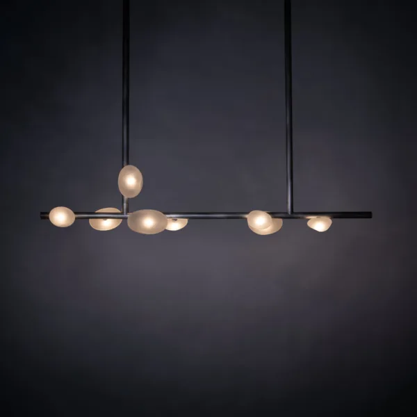 Alabaster pebble linear chandelier with glowing pebble diffusers on a dark backdrop