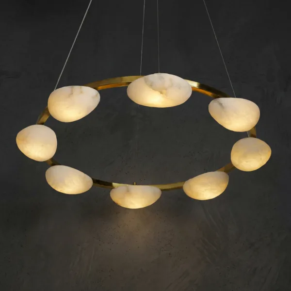 Alabaster pebble ring chandelier lit, glowing against a dark wall