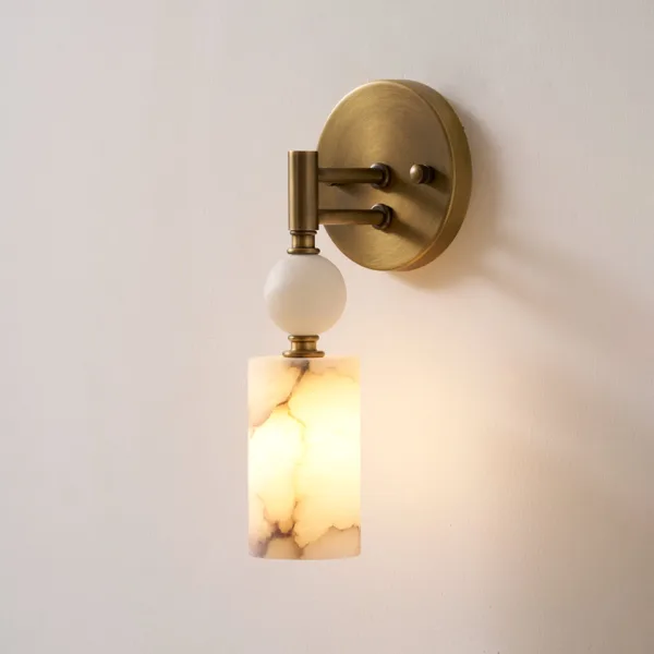 Lit alabaster cylinder below a white alabaster ball on twin brass-finish arms