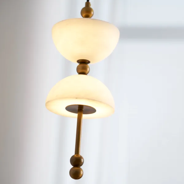 Close-up of a glowing alabaster bowl and brass rod on the alabaster staircase chandelier