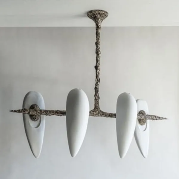 Four-alabaster teardrop chandelier unlit, seen at an angle on a light grey wall