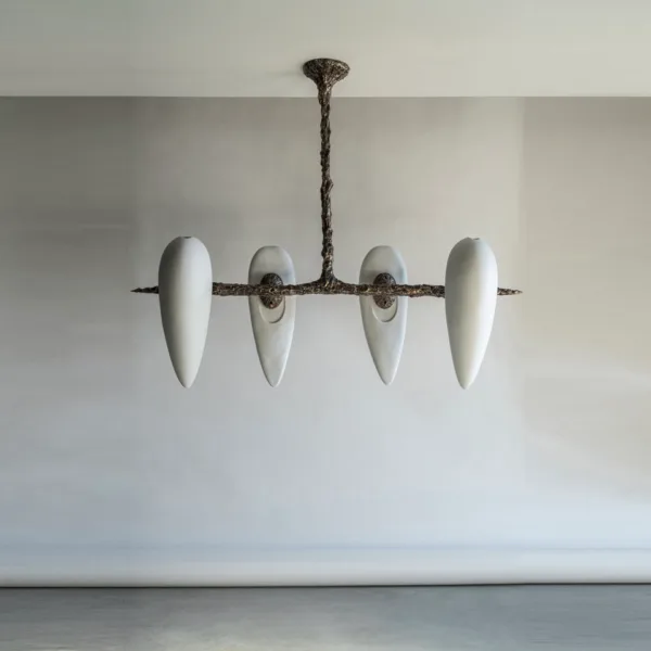Alabaster teardrop chandelier with four white alabaster drops on a cast metal frame, unlit on a pale grey wall