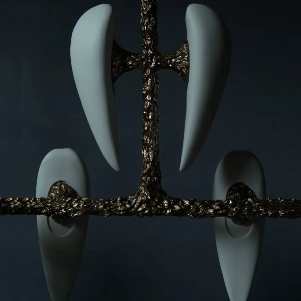 Close-up of the upper pair and a lower alabaster teardrop on the textured cast metal frame, unlit