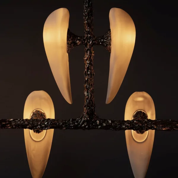Close-up of the lit alabaster teardrops glowing warm on the cast metal frame