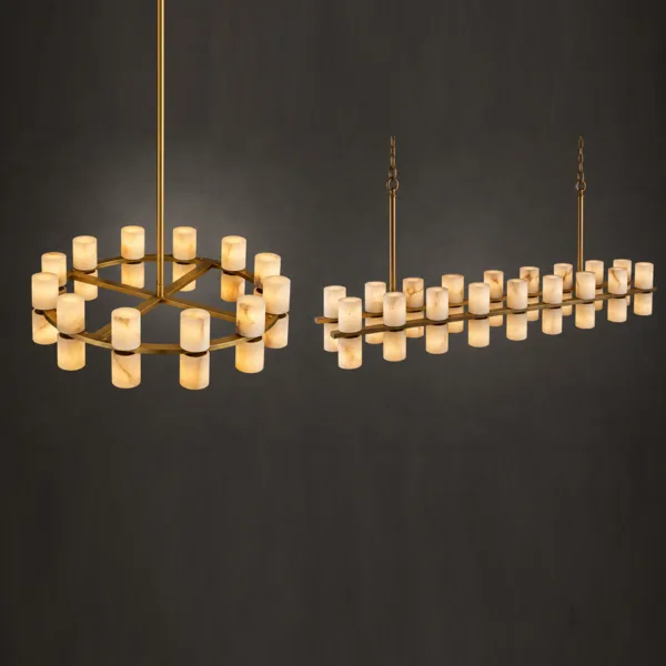 Round and linear alabaster tube chandeliers lit against a dark wall, brass frames