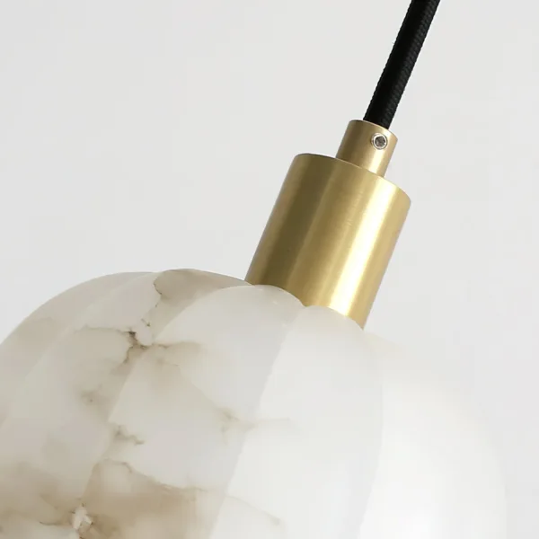 Close-up of the brass cap and black cord on the alabaster tulip chandelier