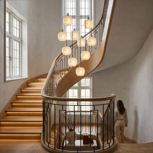 Alabaster tulip chandelier hanging in the well of a curved wooden staircase