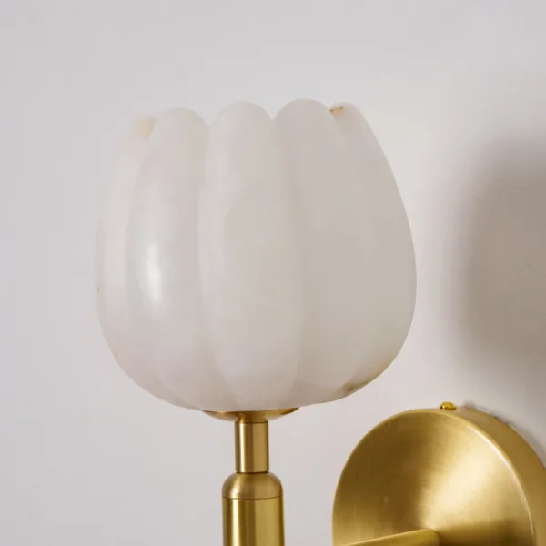 Close-up of the scalloped white alabaster tulip shade on its brass-finish stem