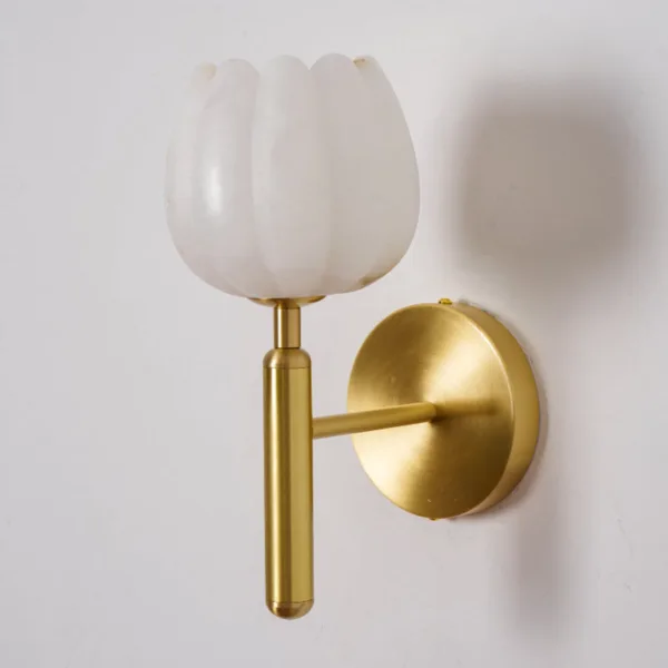 Side view of the white alabaster tulip shade, brass-finish arm and round backplate, unlit