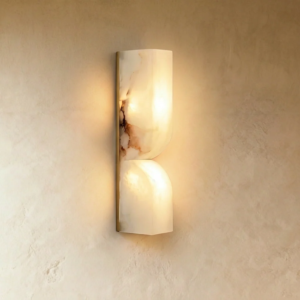 Alabaster up and down wall light glowing warm through veined natural stone on a plaster wall