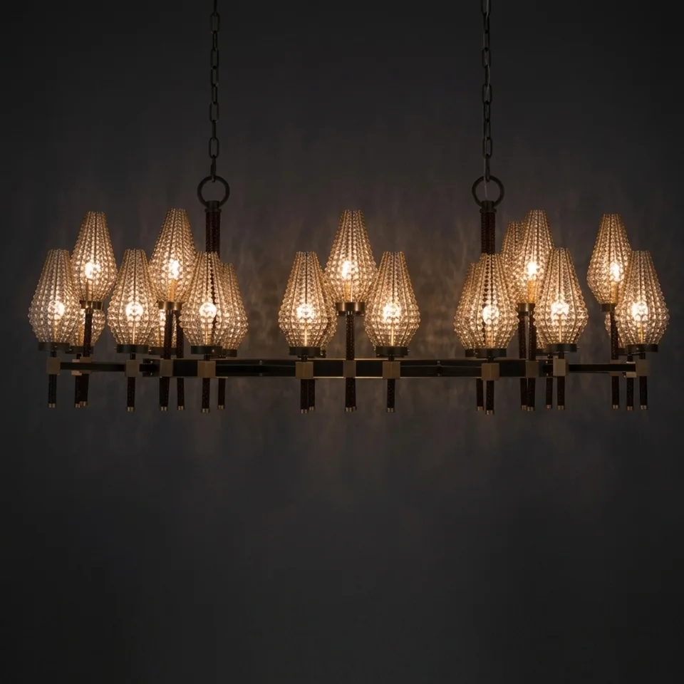 Beaded rectangular chandelier with 24 lit shades against a dark wall