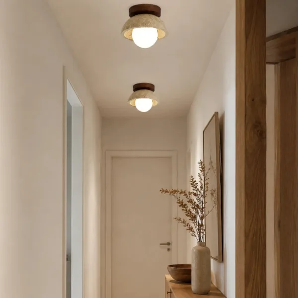 A pair of travertine and wood fittings, each a ceiling light for passage, lighting a narrow corridor