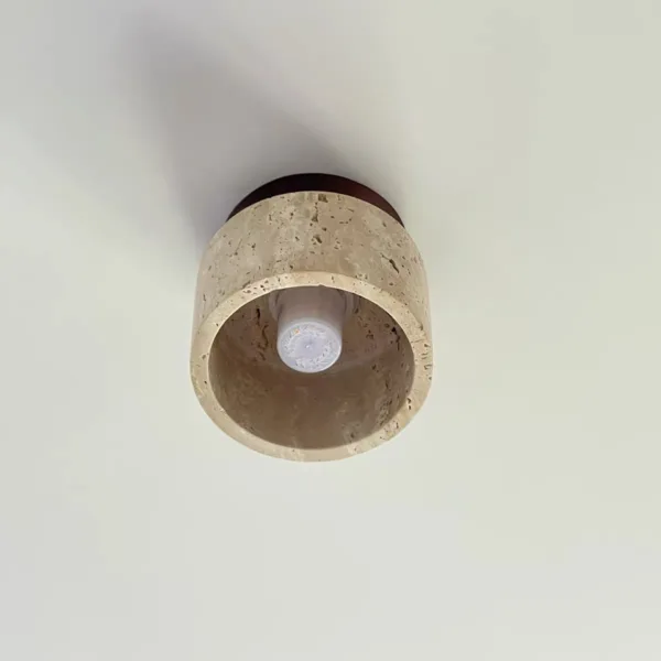 View up into the travertine drum ceiling light showing its G9 bulb inside the stone
