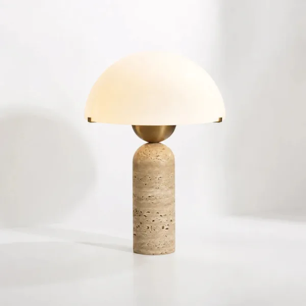 Lit opal borosilicate glass dome of the travertine table lamp glowing soft white