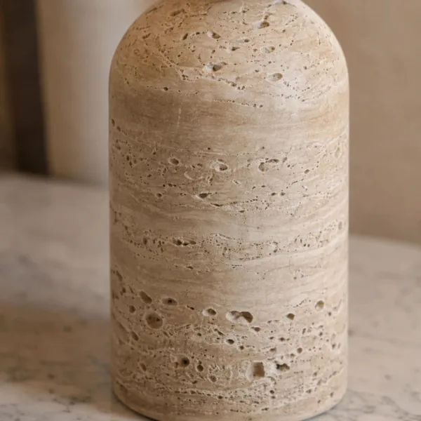 Close-up of the honed travertine column base with its natural pits and fine banding