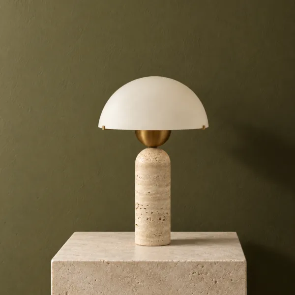 Travertine and opal glass lamp standing on a stone plinth in front of a deep green wall