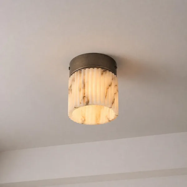 Fluted light glowing warm on a white ceiling, alabaster veins showing through the flutes