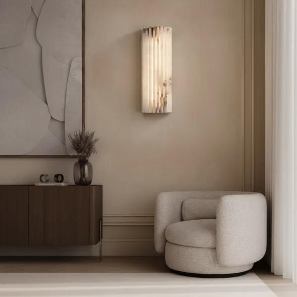 Fluted alabaster wall light above a walnut sideboard beside a boucle armchair in a living room