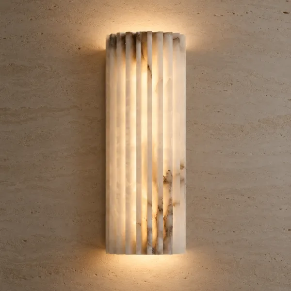 Fluted alabaster wall light glowing warm on a travertine stone wall