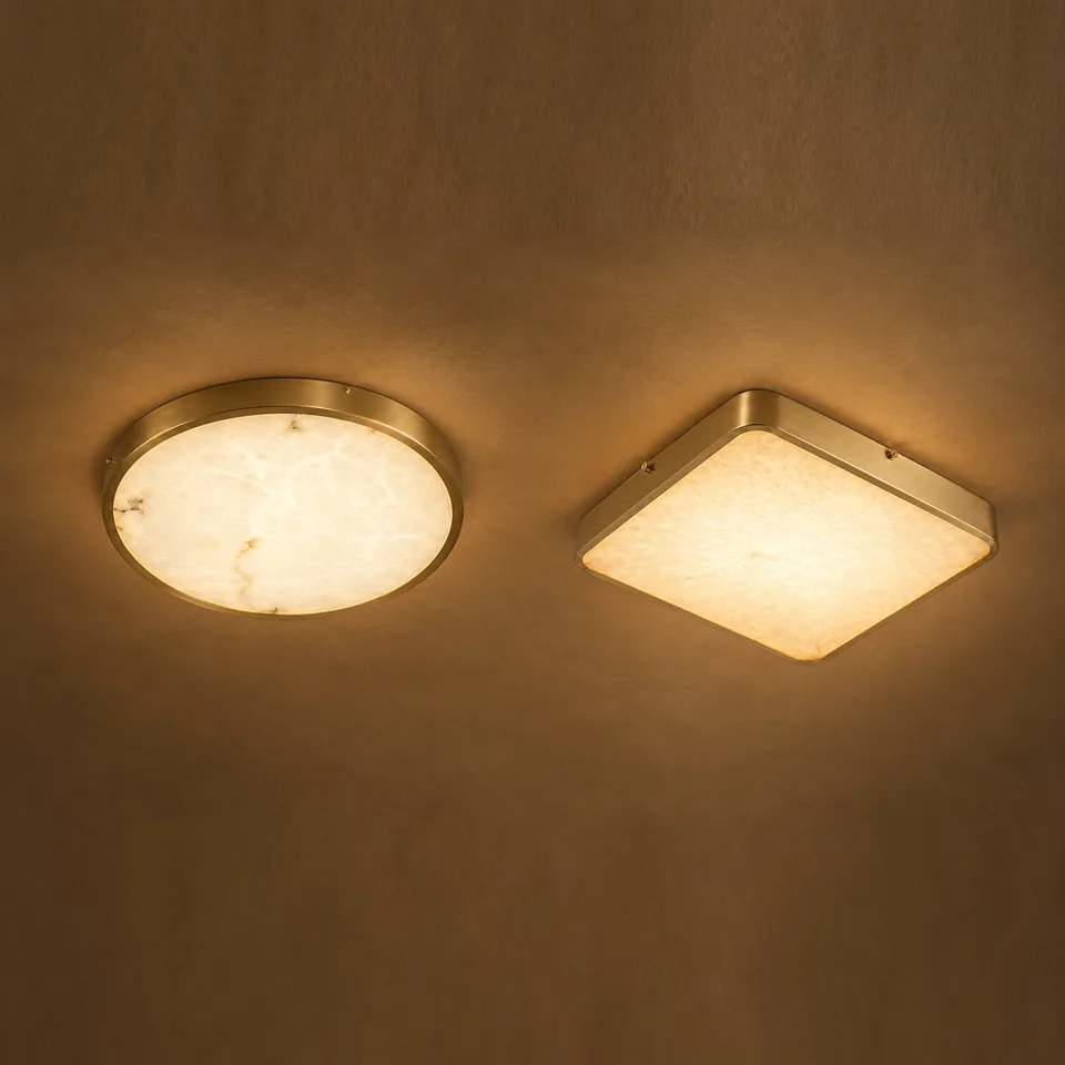 Gold ceiling lights in alabaster, round and square, glowing warm on a ceiling