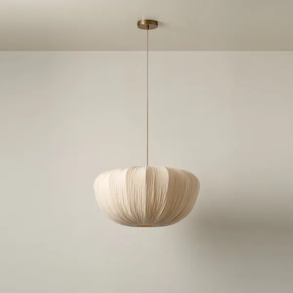 Japanese fabric cloud pendant light with a pleated cream shade and brass canopy against a beige wall