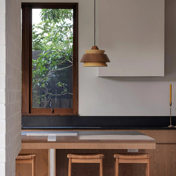 Layered wood pendant light over a kitchen worktop with wooden stools
