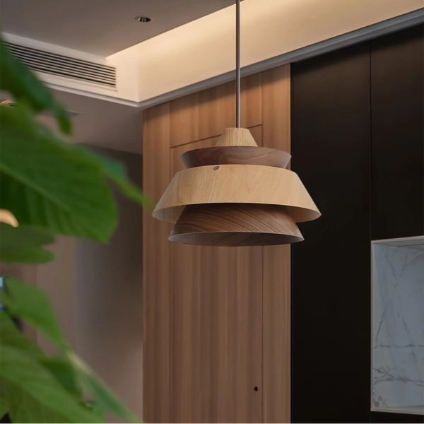 Layered wood pendant light in a modern kitchen with wood and black cabinets