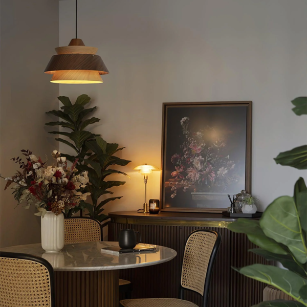 Layered wood pendant light above a round dining table with cane chairs