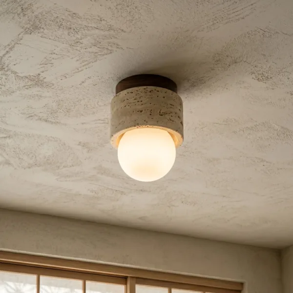 Mini travertine ceiling light glowing on a textured plaster ceiling