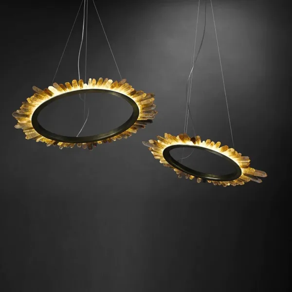 Two modern crystal ring chandeliers glowing, crystal points around brass rings