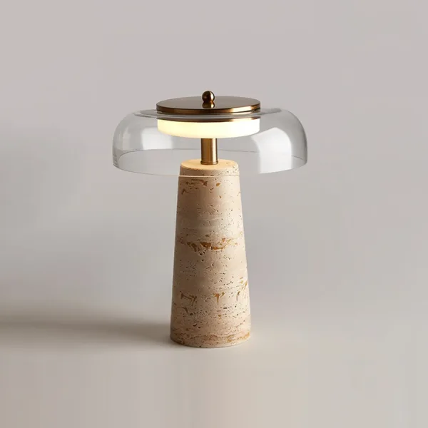 Front view of the travertine table lamp with its clear borosilicate glass dome and brass-finish cap