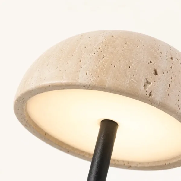 Underside of the travertine dome showing the soft white diffuser that spreads the light