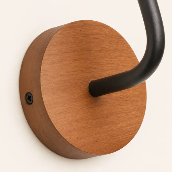Detail of the round real wood backplate and matte black stainless steel stem of the sconce