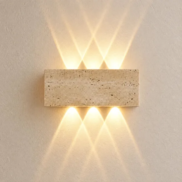 Travertine outdoor up and down light close up on a cream wall, warm beams crossing above and below