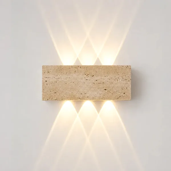 Outdoor up and down light in real travertine, lit on a white wall with three beams up and three down