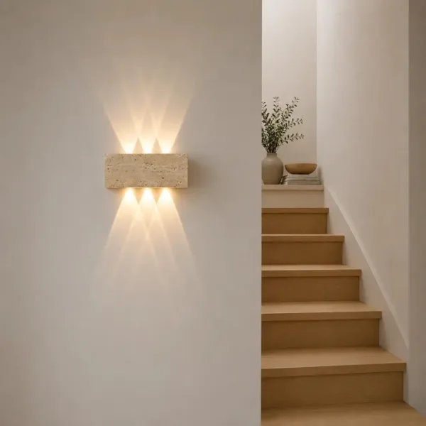 Travertine up and down light on a white stair wall beside wooden steps, lit warm up and down