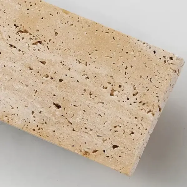 Close-up of the real travertine face of the up and down light, its natural pits left open